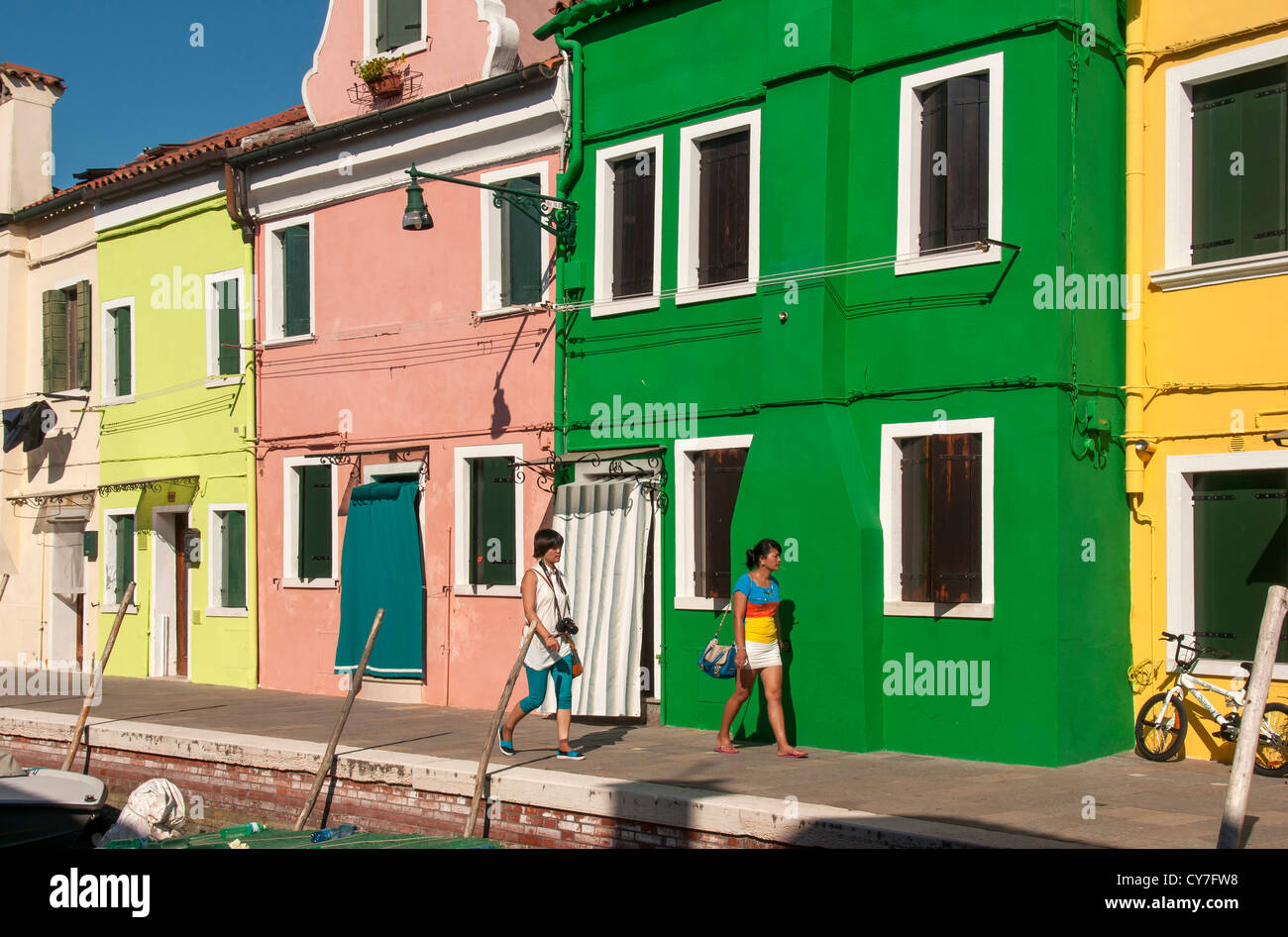 Deux jeunes femmes maisons peintes de couleurs vives, Burano, Venise, Vénétie, Italie Banque D'Images