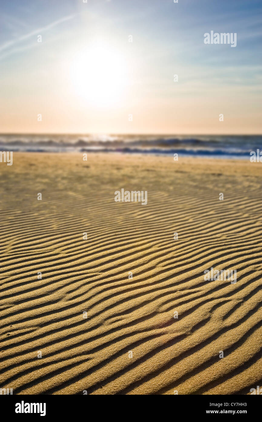 Plage Sable ondulations floues avec les vagues de l'océan & Sun, Ocean City, Maryland, USA Banque D'Images