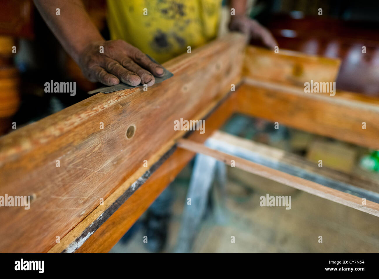 Un travailleur menuiserie lustre le coffret en bois avec un papier de verre fin à une table football workshop à Quito, Équateur. Banque D'Images