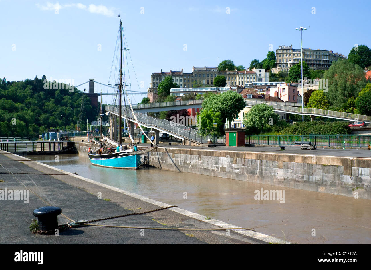 Bateau à voile dans le bassin de Cumberland, verrouillage avec clifton et le pont suspendu dans la distance, bristol. Banque D'Images