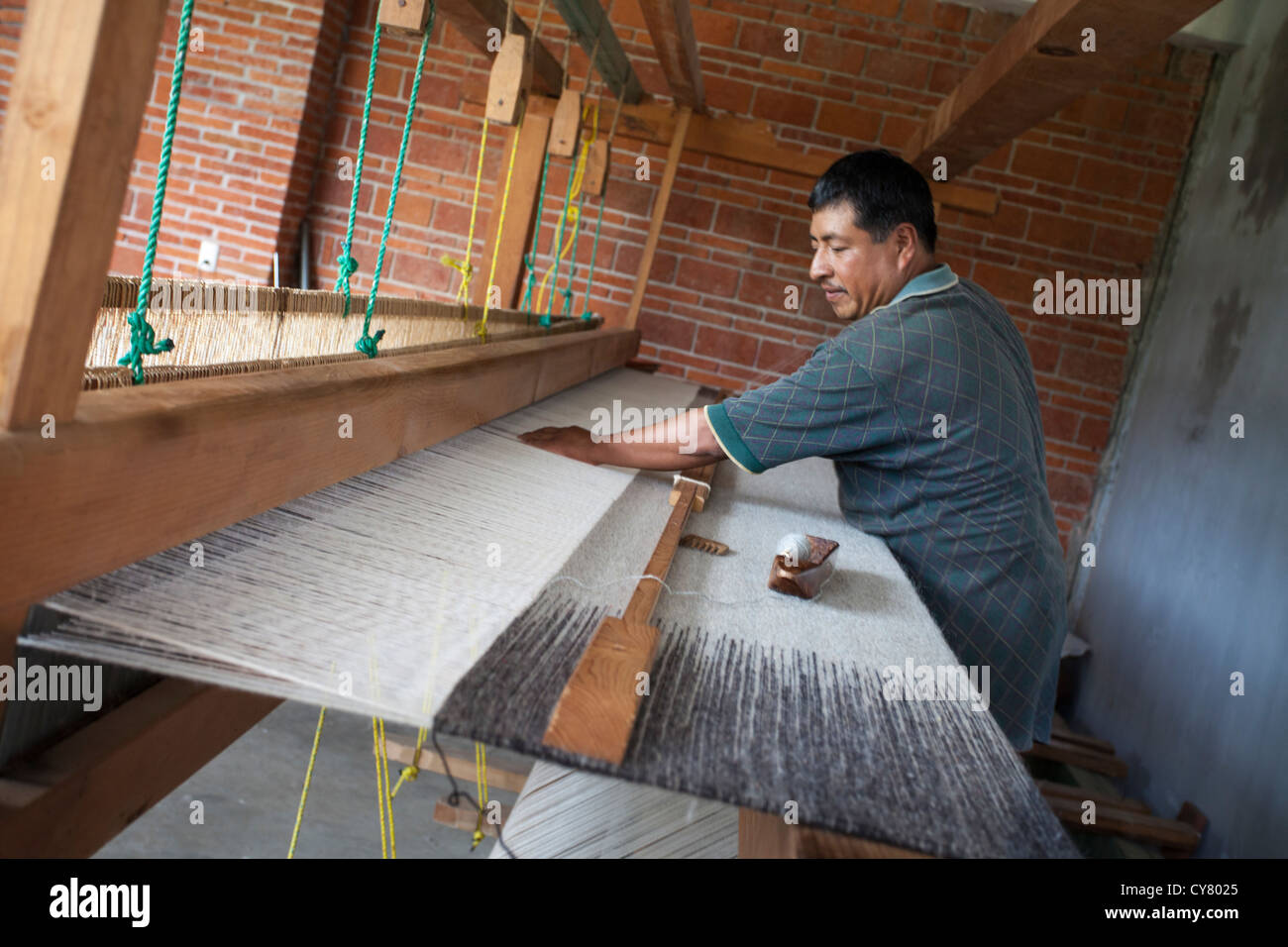 Weaver à Manos Que atelier Tejen crée un tapis de laine sur un métier à tisser en bois à Teotitlan del Valle, Oaxaca, Mexique. Banque D'Images
