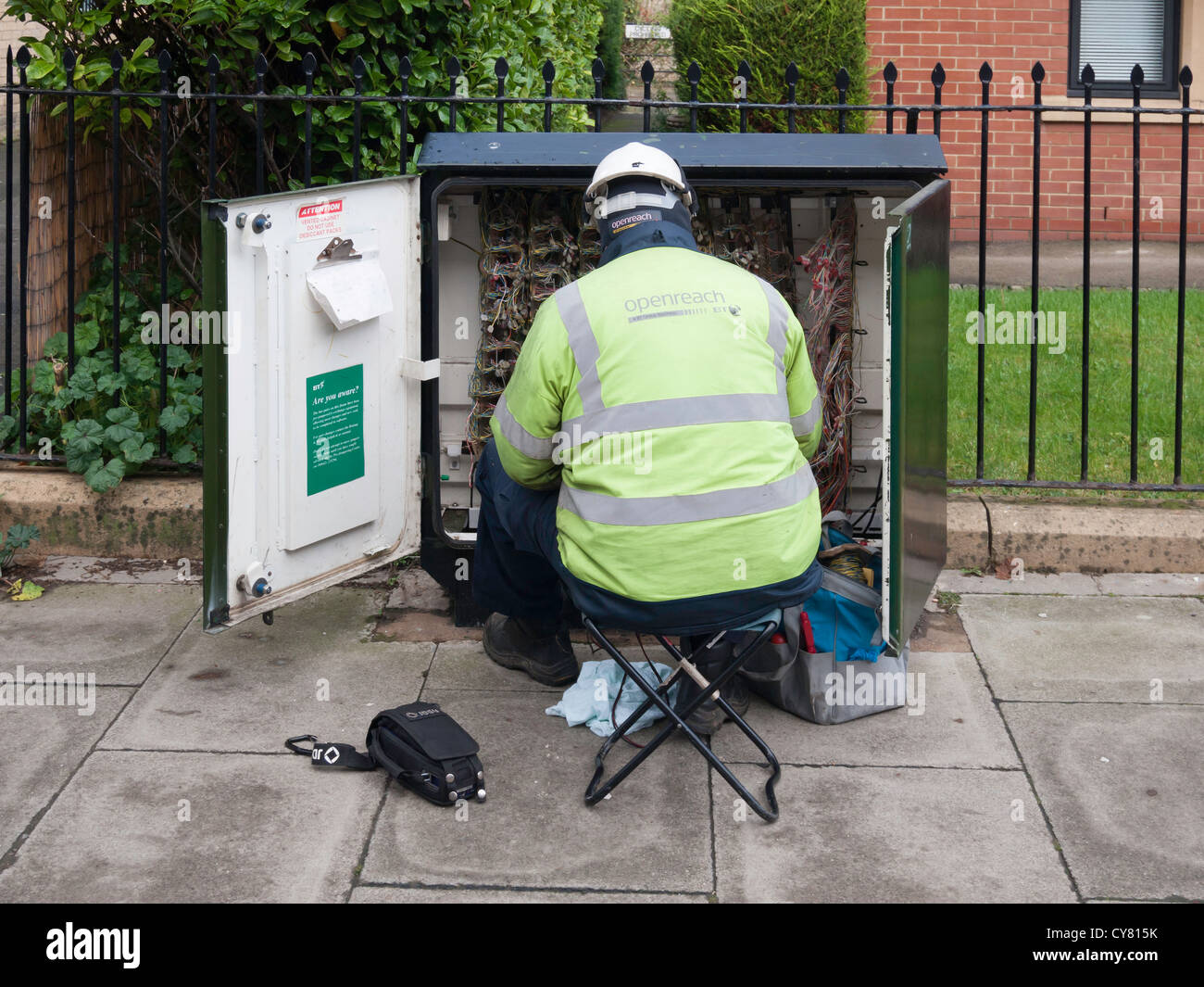 Un technicien en télécommunications BT Openreach travaillant sur un équipement en bordure du cabinet Banque D'Images