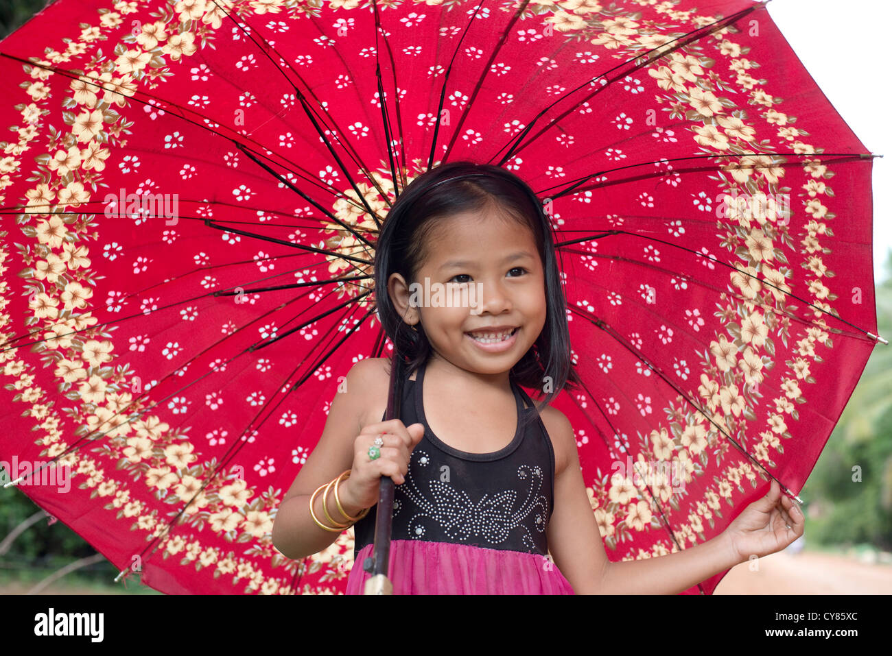 Une jeune fille pose pour son portrait avec un parapluie rouge en O'Ambel  village, Sisophon, Cambodge Photo Stock - Alamy