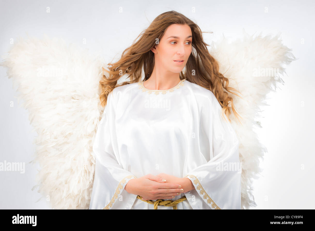 Femme en costume avec des ailes en plumes artificiel isolé sur fond blanc spiritualité religion rêves de pureté Banque D'Images