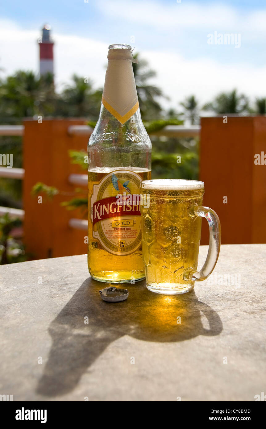 Close up vertical d'une bouteille de bière fraîche Kingfisher et un verre sur une table à Kovalam, Inde. Banque D'Images