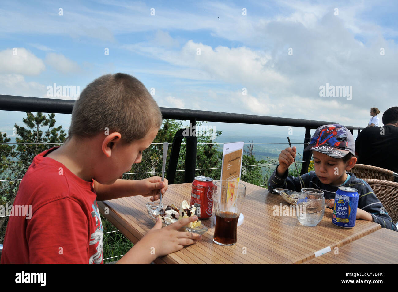 Les jeunes garçons de manger sur la terrasse du pic Puy de Dome Auvergne France Banque D'Images