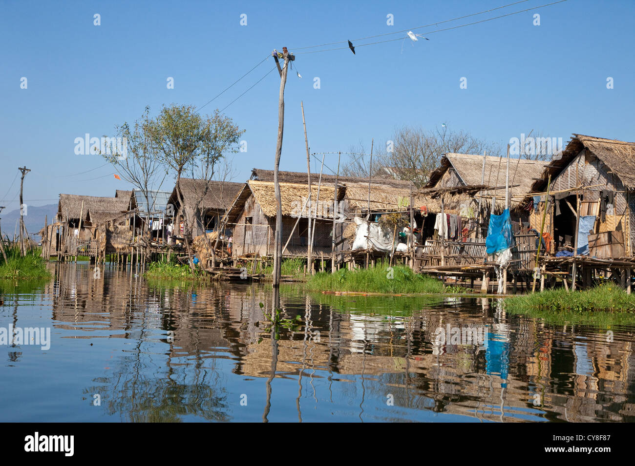 Le Myanmar, Birmanie. Maisons de village sur pilotis le long de cours d'eau, lac Inle, l'État Shan. Banque D'Images