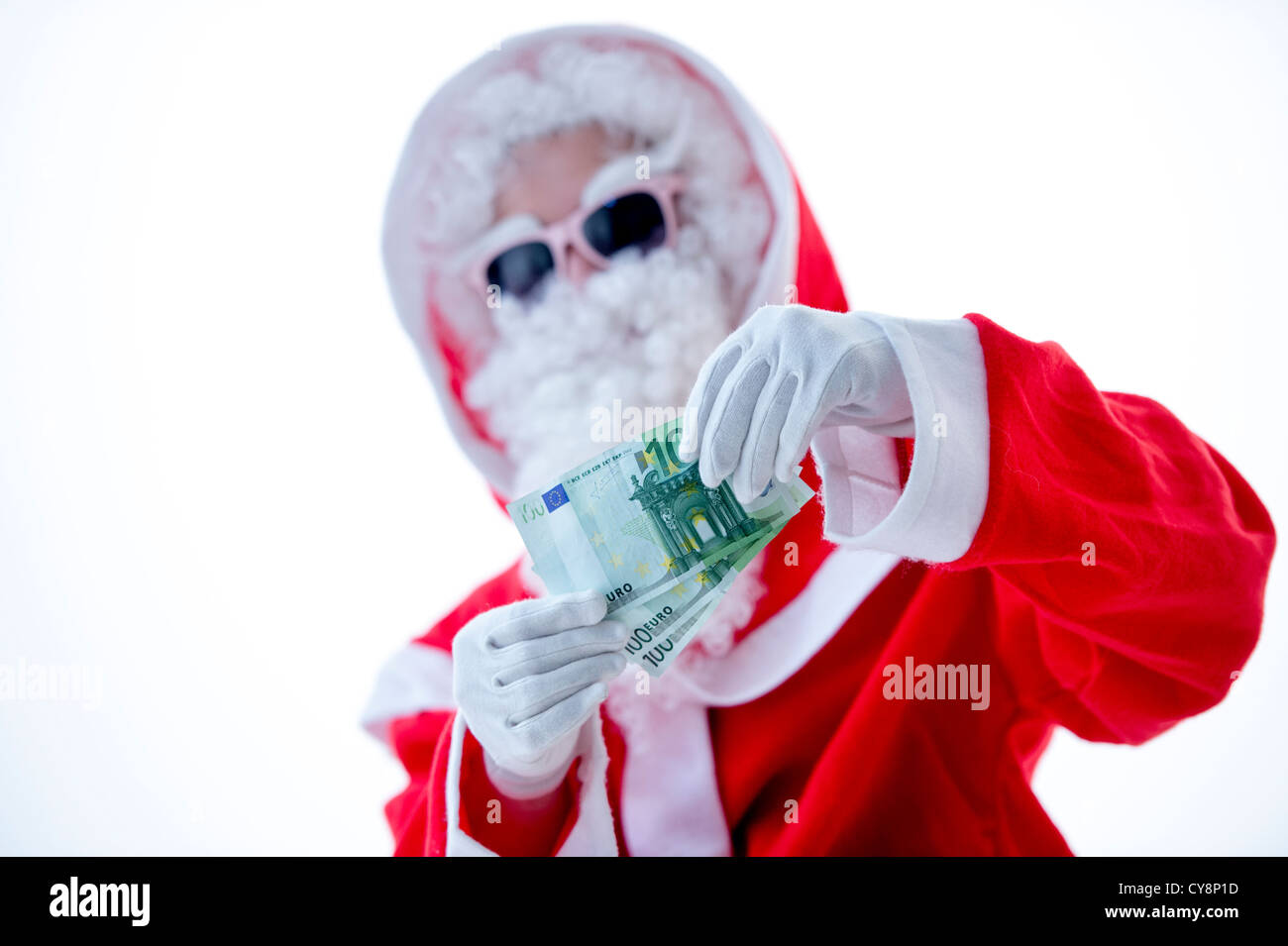 Cool Santa Claus avec des lunettes roses posant avec l'introduction des billets isolé sur fond blanc Banque D'Images