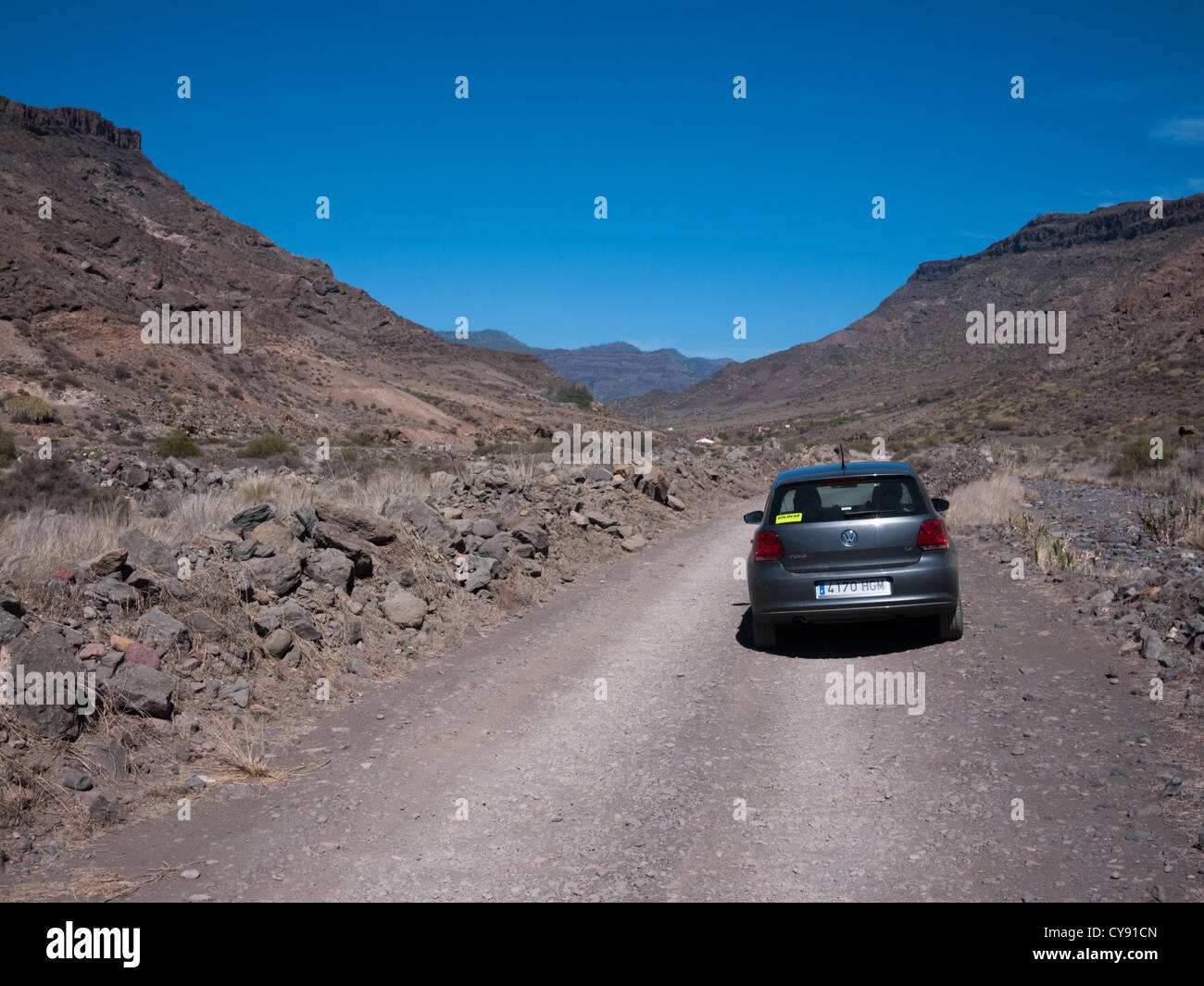 Paysage aride avec VW Polo voiture sur route à Veneguera Gran Canaria Îles Canaries Espagne Banque D'Images