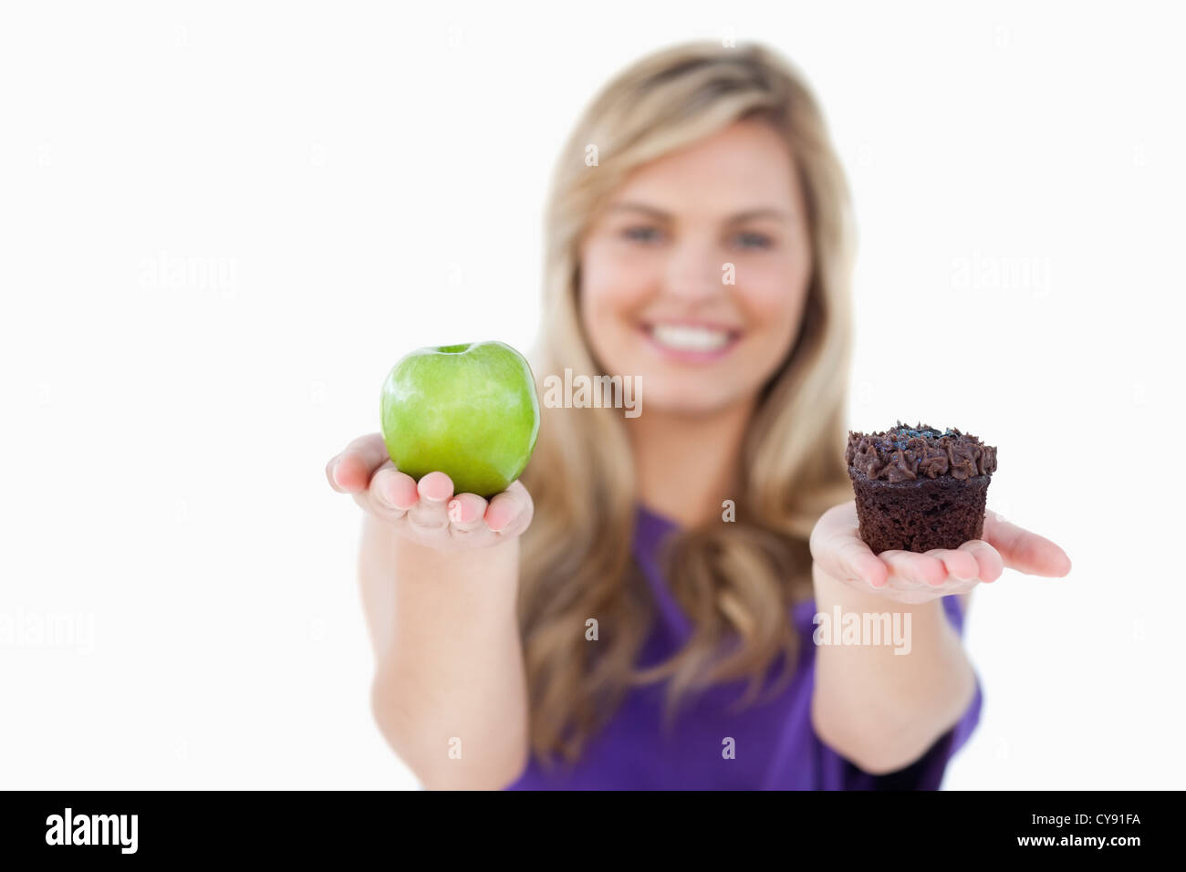 Un fruit et un muffin étant détenu par une femme blonde Banque D'Images