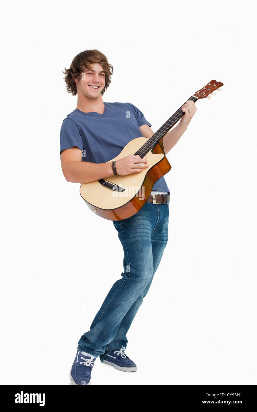 Male student posing tout en jouant de la guitare Banque D'Images