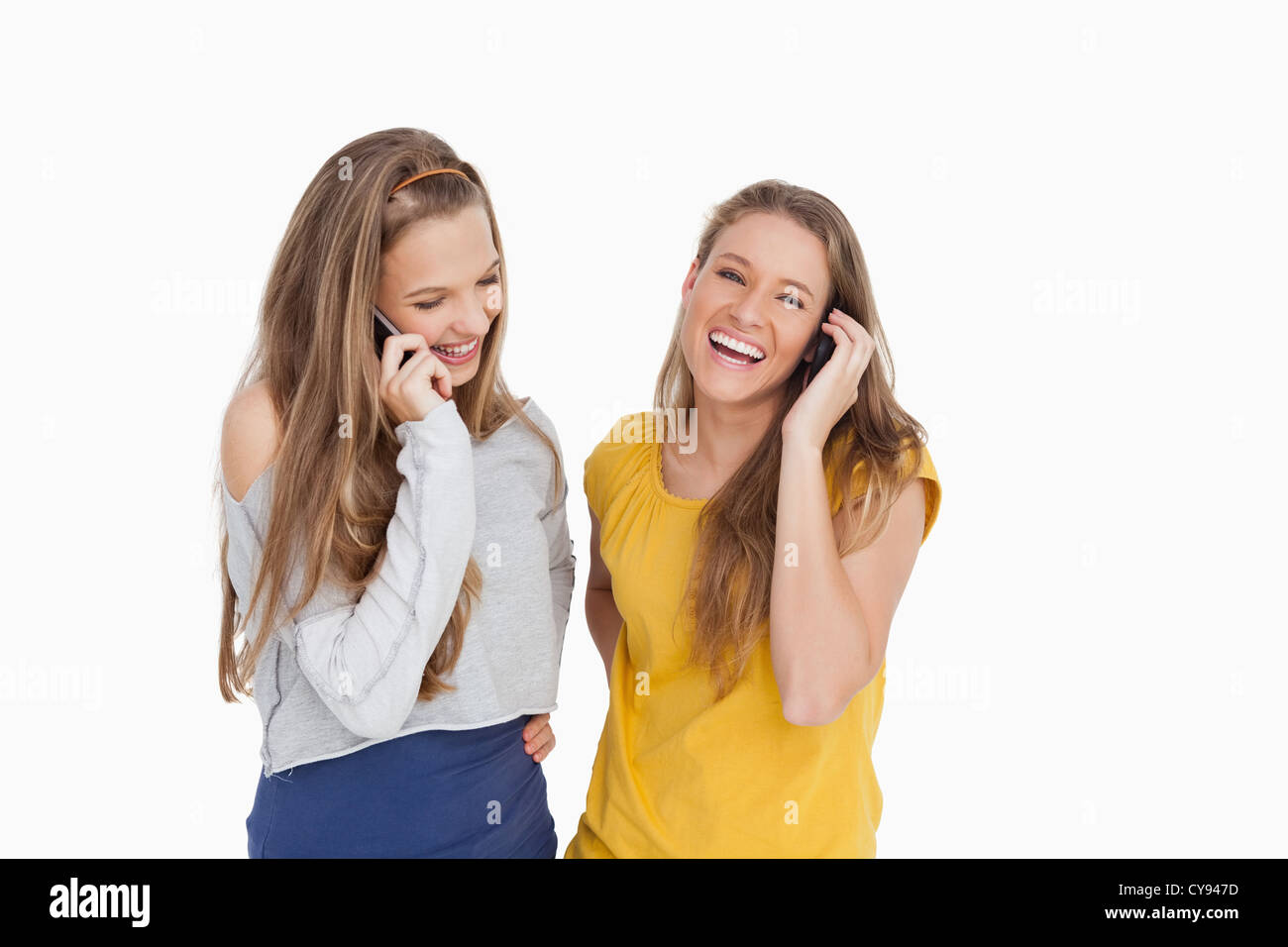 Deux jeunes femmes de rire au téléphone Banque D'Images