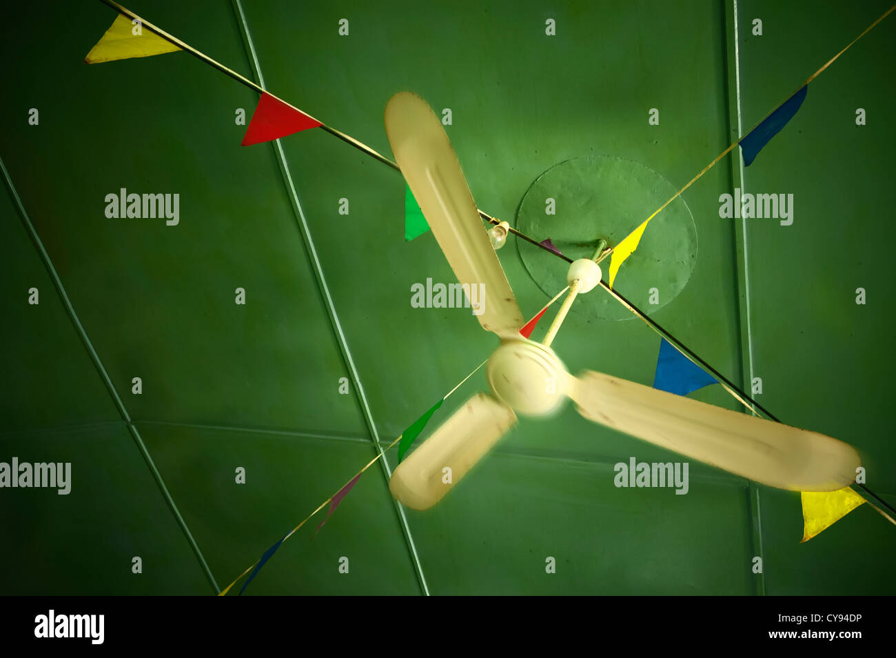 Ancien plafond ventilateur tourne dans un café décoré de guirlandes multicolores au plafond Banque D'Images