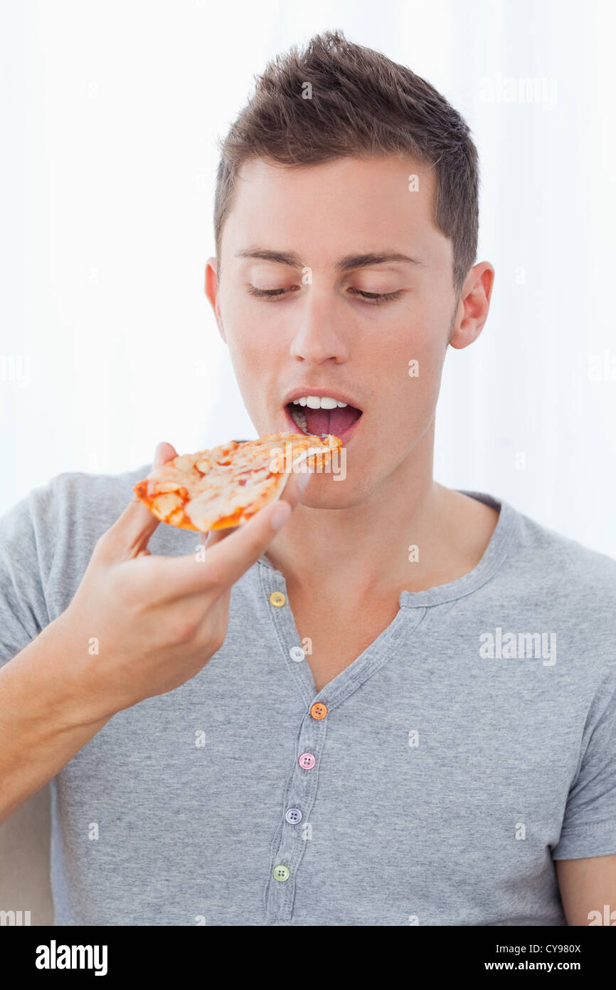 Close up d'un homme tel qu'il est sur le point de manger la tranche de pizza il est en train de regarder Banque D'Images