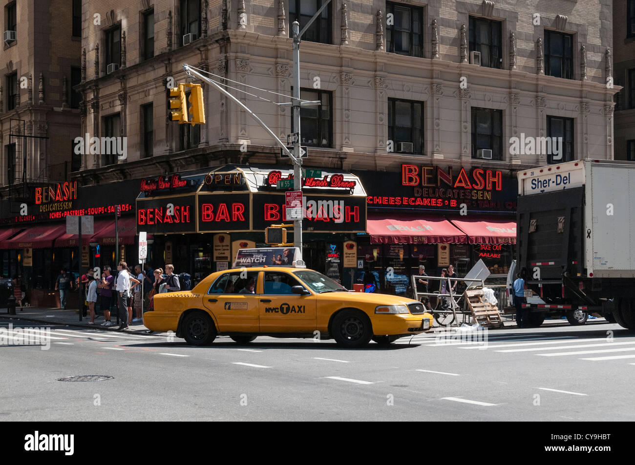 New York City intersection de la 7e Avenue et West 55th Street pendant la journée montrant Benashi Delicatessen, personnes et taxi. Banque D'Images