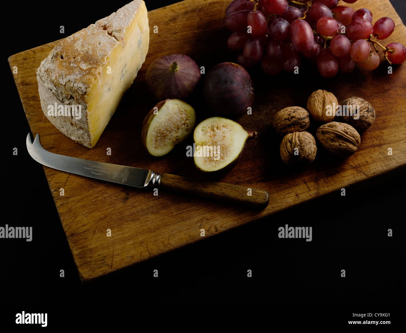 Plateau de fromage avec du fromage, Raisins, Figues et Noix sur une planche à découper. Banque D'Images