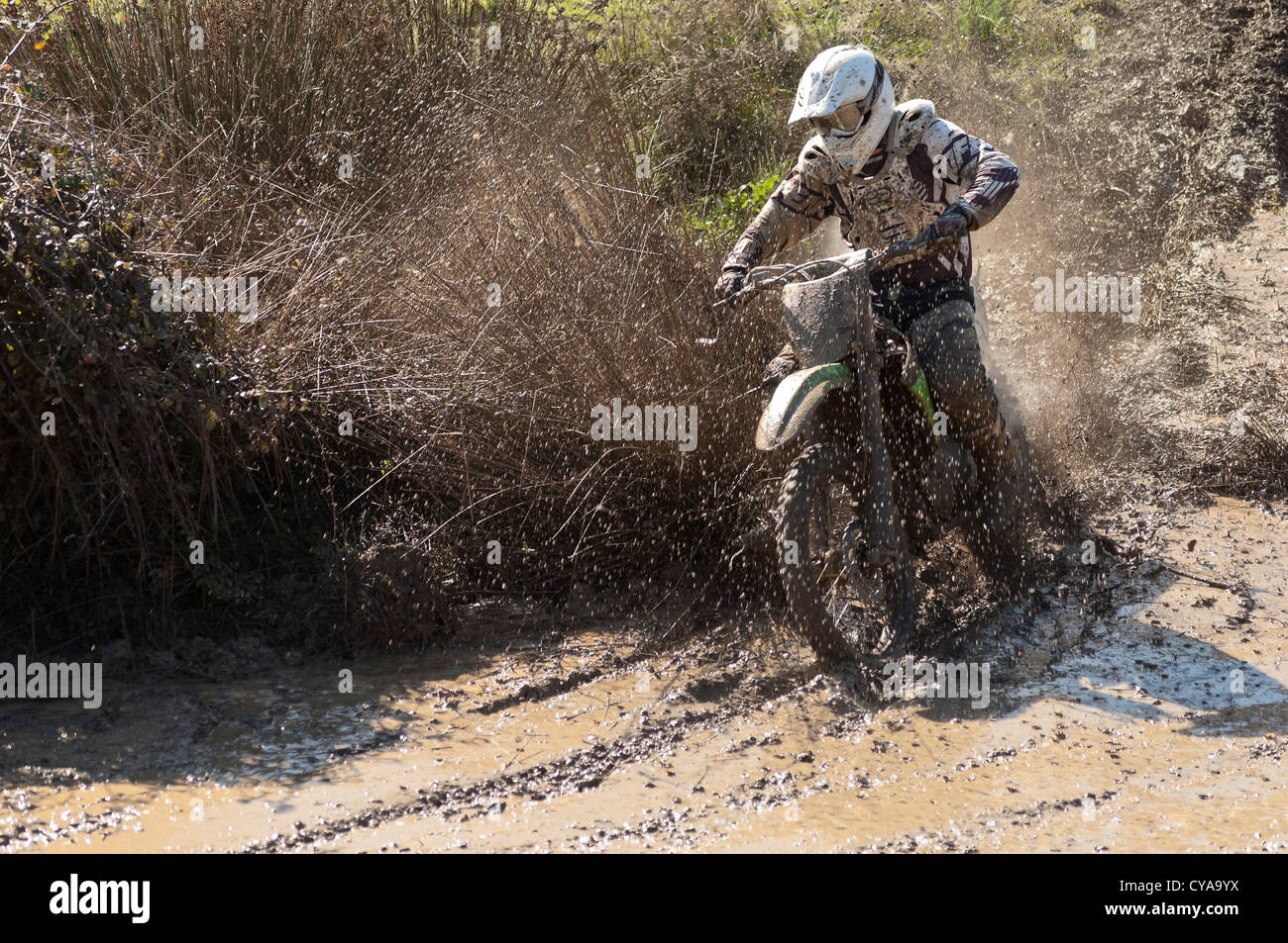 Rider Motocross traversant un ruisseau Muddy sur la piste d'Safara, Alentejo, Portugal Banque D'Images