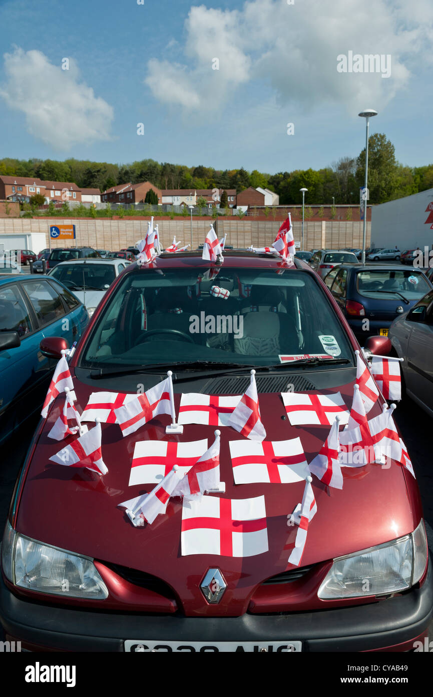 Une voiture Renault rouge garée recouverte de la croix anglaise des drapeaux de St George en préparation de la coupe du monde de la FIFA 2010. Banque D'Images