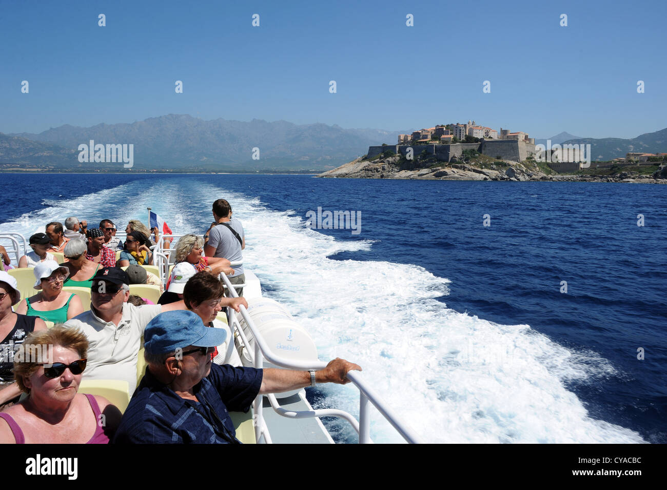 Les touristes sur un bateau d'excursion de quitter la ville de Calvi en direction de la réserve naturelle de Scandola en Corse, France. Banque D'Images