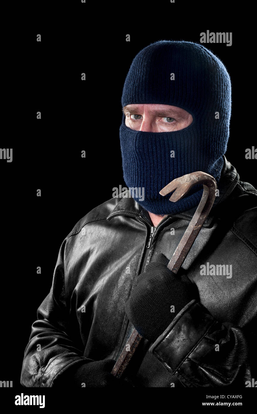 Un voleur portant un masque de ski pour cacher son identité est titulaire d'un pied de biche et se prépare à commettre un crime. Banque D'Images