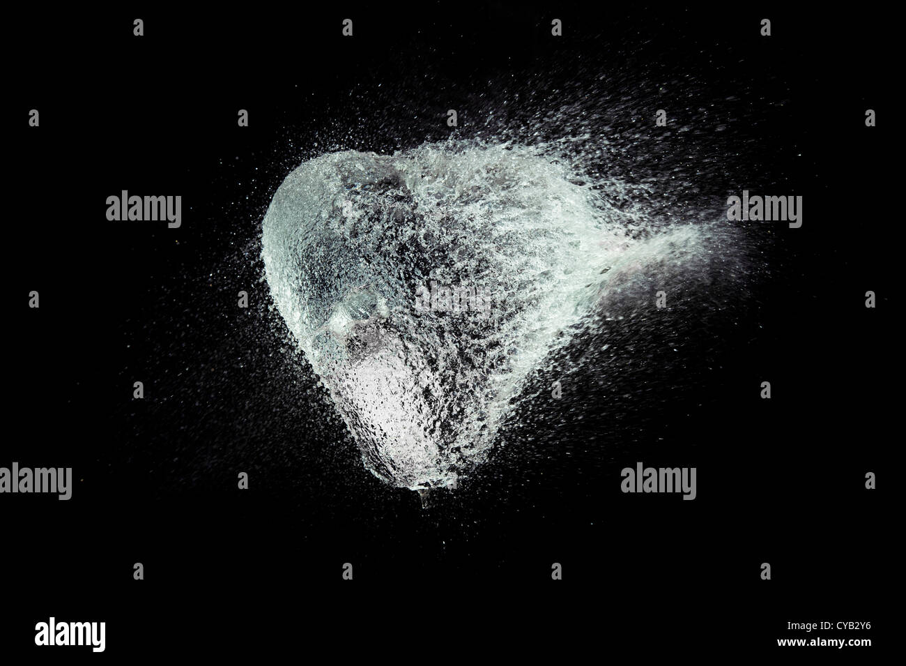 Ballon d'eau en forme de coeur de rupture sur un fond noir Banque D'Images