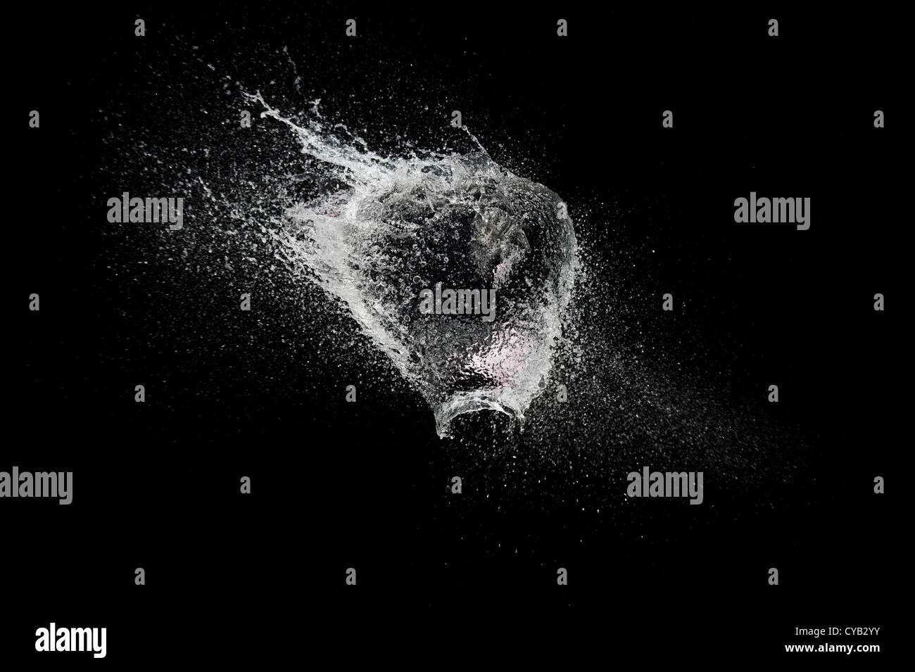 Ballon d'eau en forme de coeur de rupture sur un fond noir Banque D'Images