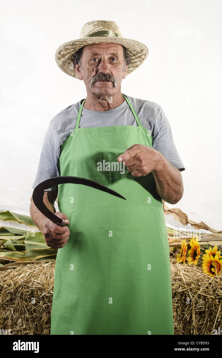Agriculteur biologique avec une petite faucille d'herbe dans sa main Banque D'Images