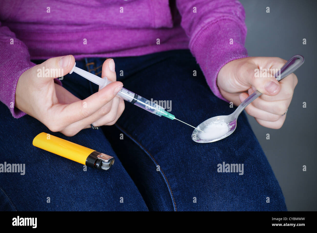 Attirail de drogue : jeune femme junkie préparer l'héroïne ou l'aime pour l'injection à la seringue. Banque D'Images