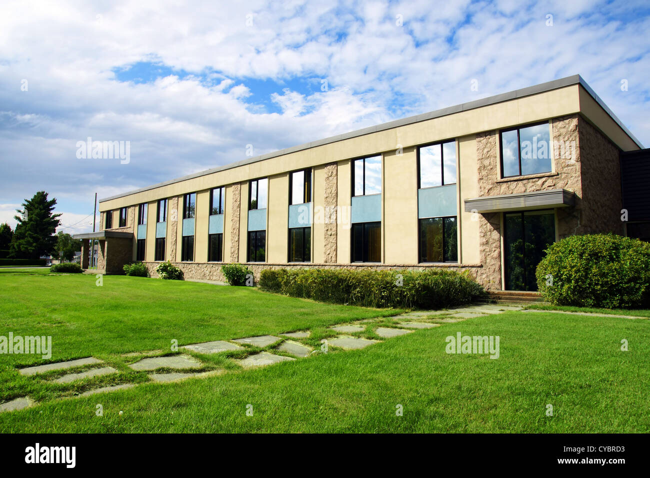 Petit bureau ou bâtiment d'entreprise ou d'un collège perspective scolaire tourné avec Sky et de l'herbe. Banque D'Images