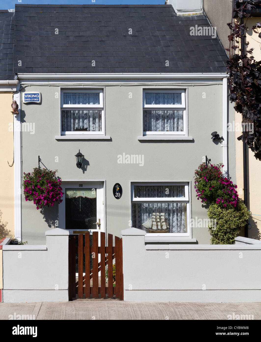 Petite maison mitoyenne avec paniers de fleurs suspendus Banque D'Images