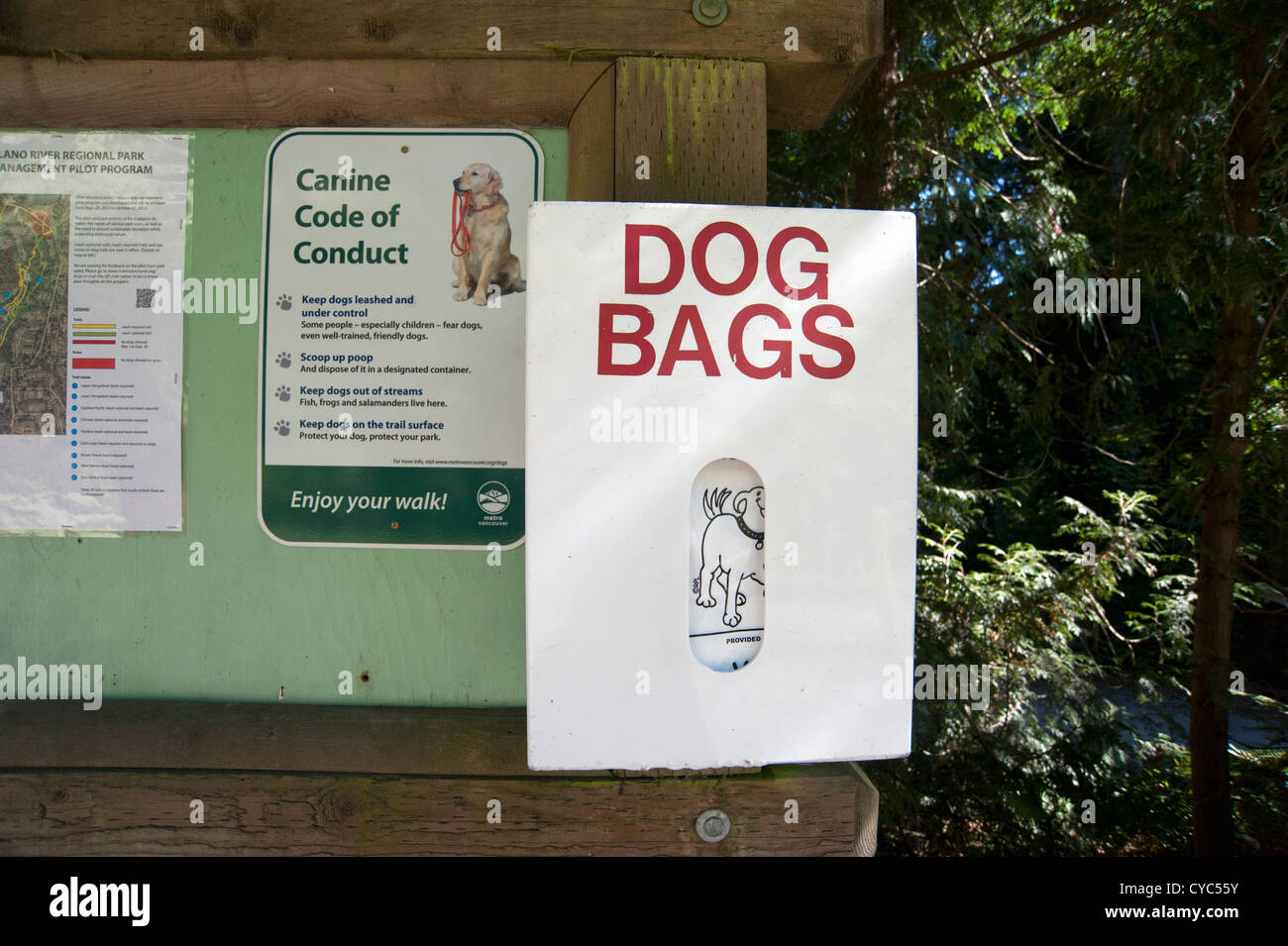 Un babillard au début d'un sentier dans la forêt a un panneau pour le code de conduite et d'une fourniture de sacs de chien Banque D'Images