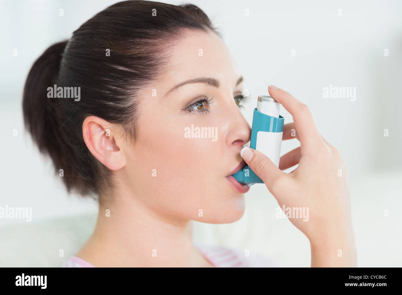 Femme à l'aide d'un inhalateur d'asthme Banque D'Images