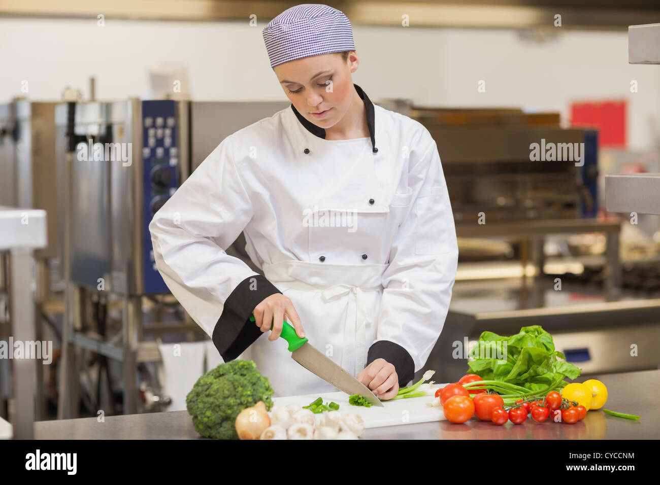 Chef slicing up oignons de printemps Banque D'Images