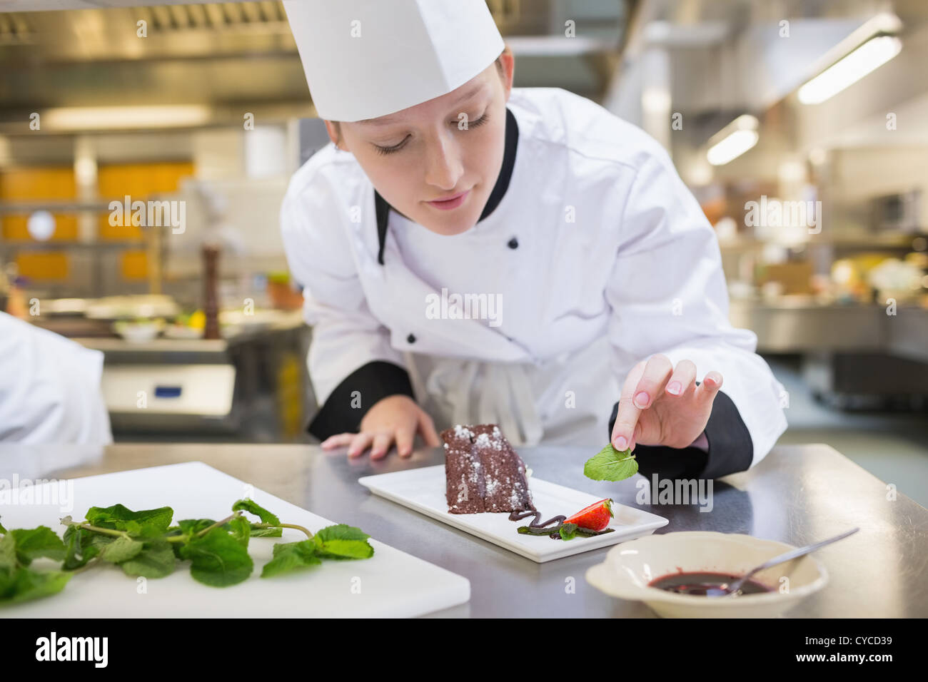 Chef putting mint avec son gâteau au chocolat Banque D'Images