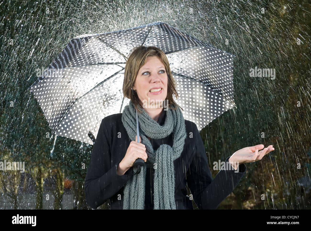 Une femme sous un parapluie lors de fortes pluies Banque D'Images