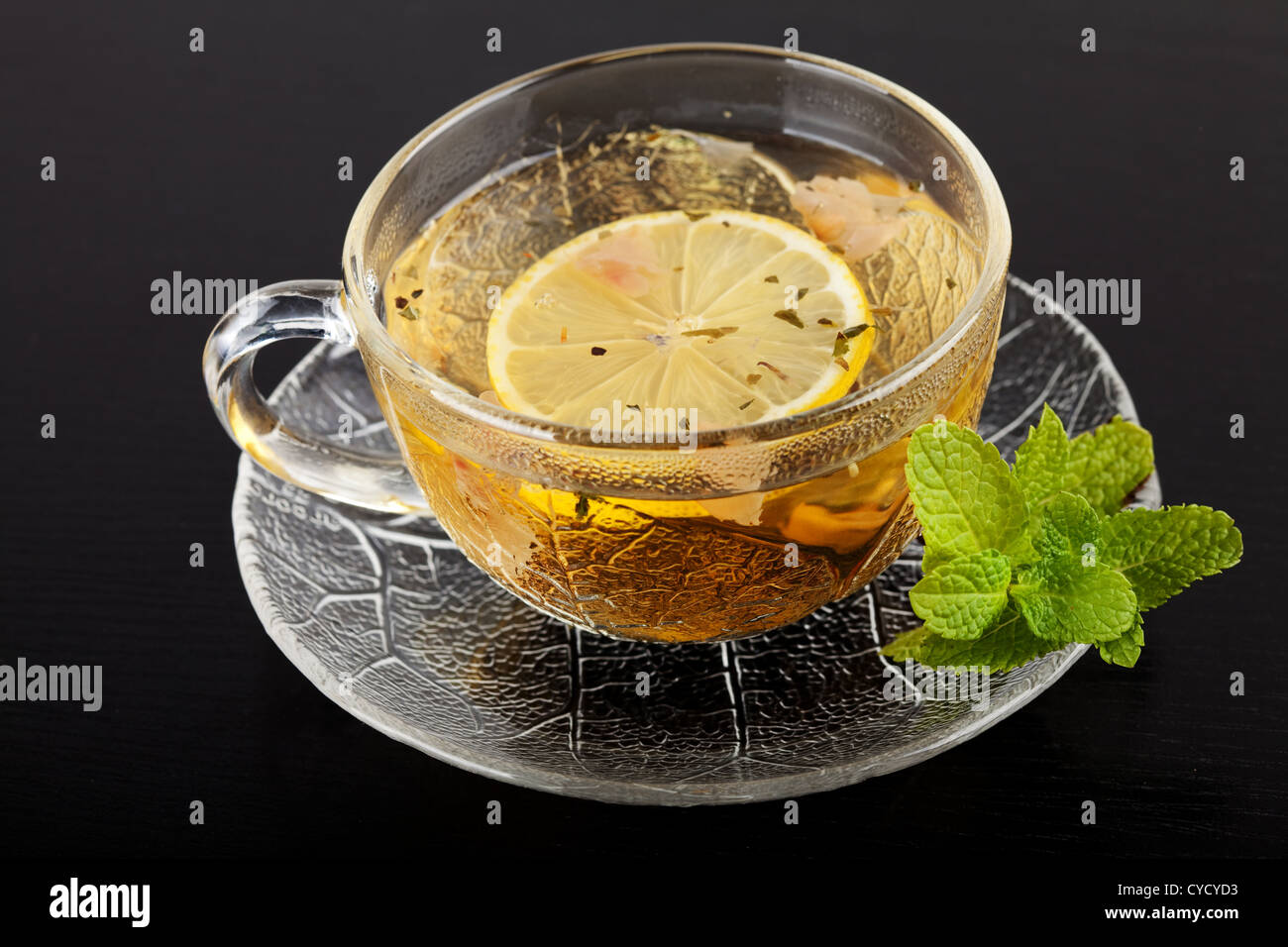 Tasse de thé vert avec du citron et de la menthe sur la table en bois sombre. Banque D'Images