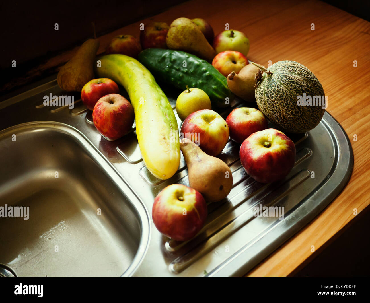 Collection biologique : sélection aléatoire de fruits et légumes cueillis à maturité de la maison jardin - pomme, poire, melon, concombre Banque D'Images