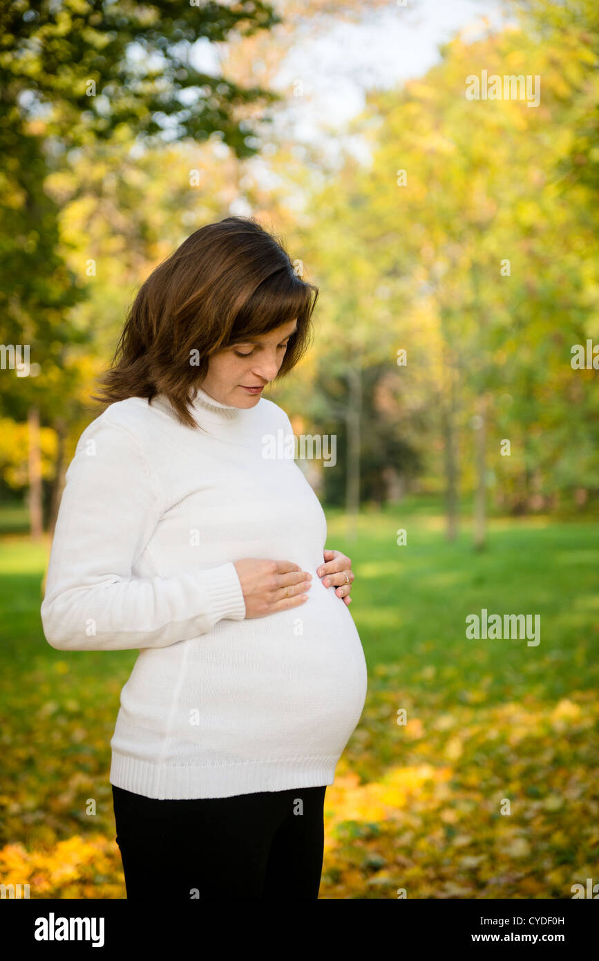 Young happy pregnant woman outdoor en automne nature Banque D'Images