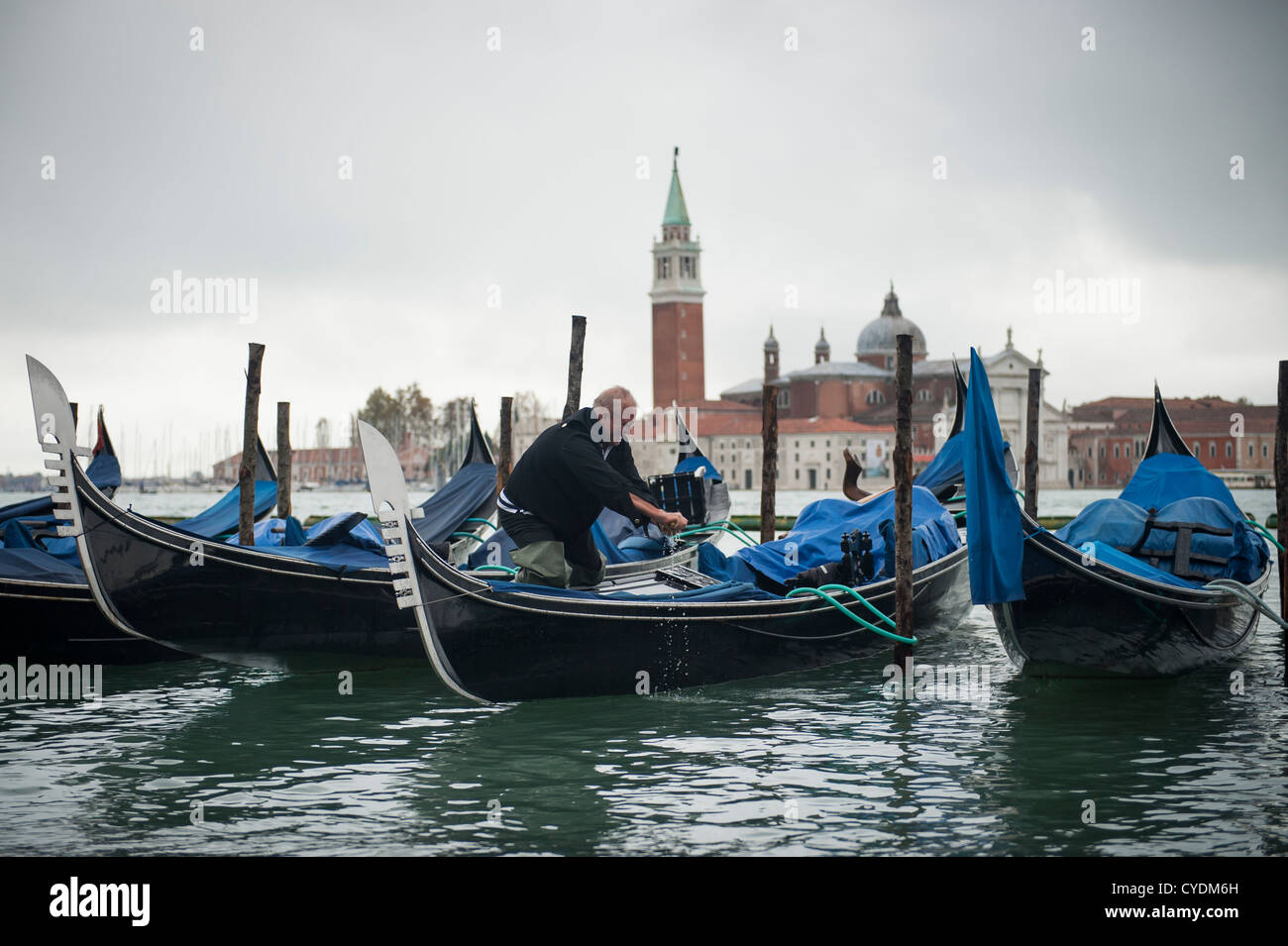 Gondolier écoule son Gondola se préparer pour les touristes, Venise, Italie. Banque D'Images