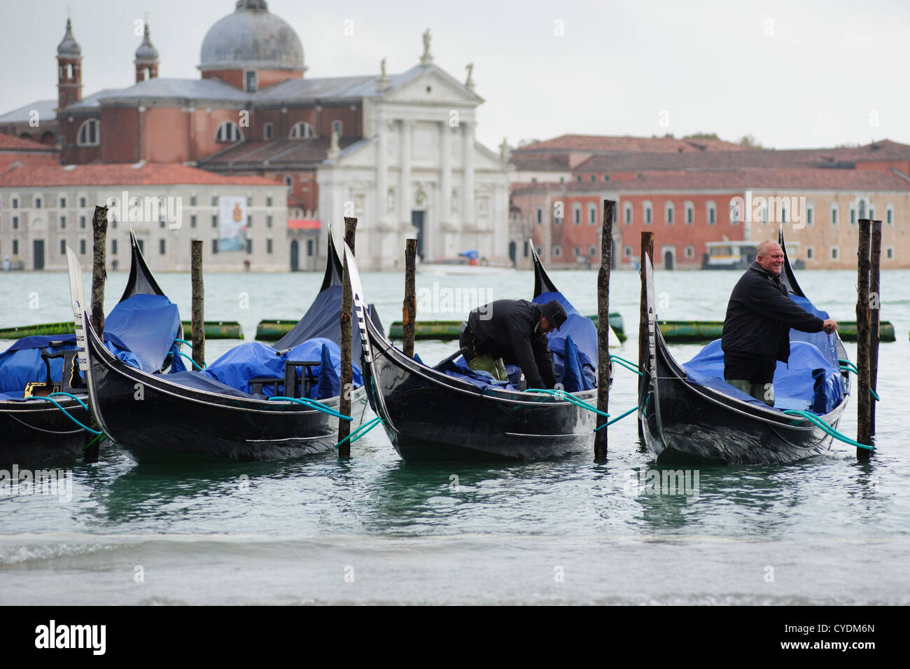 Gondoliers écouler leurs gondoles étant prêt pour les touristes, Venise, Italie. Banque D'Images