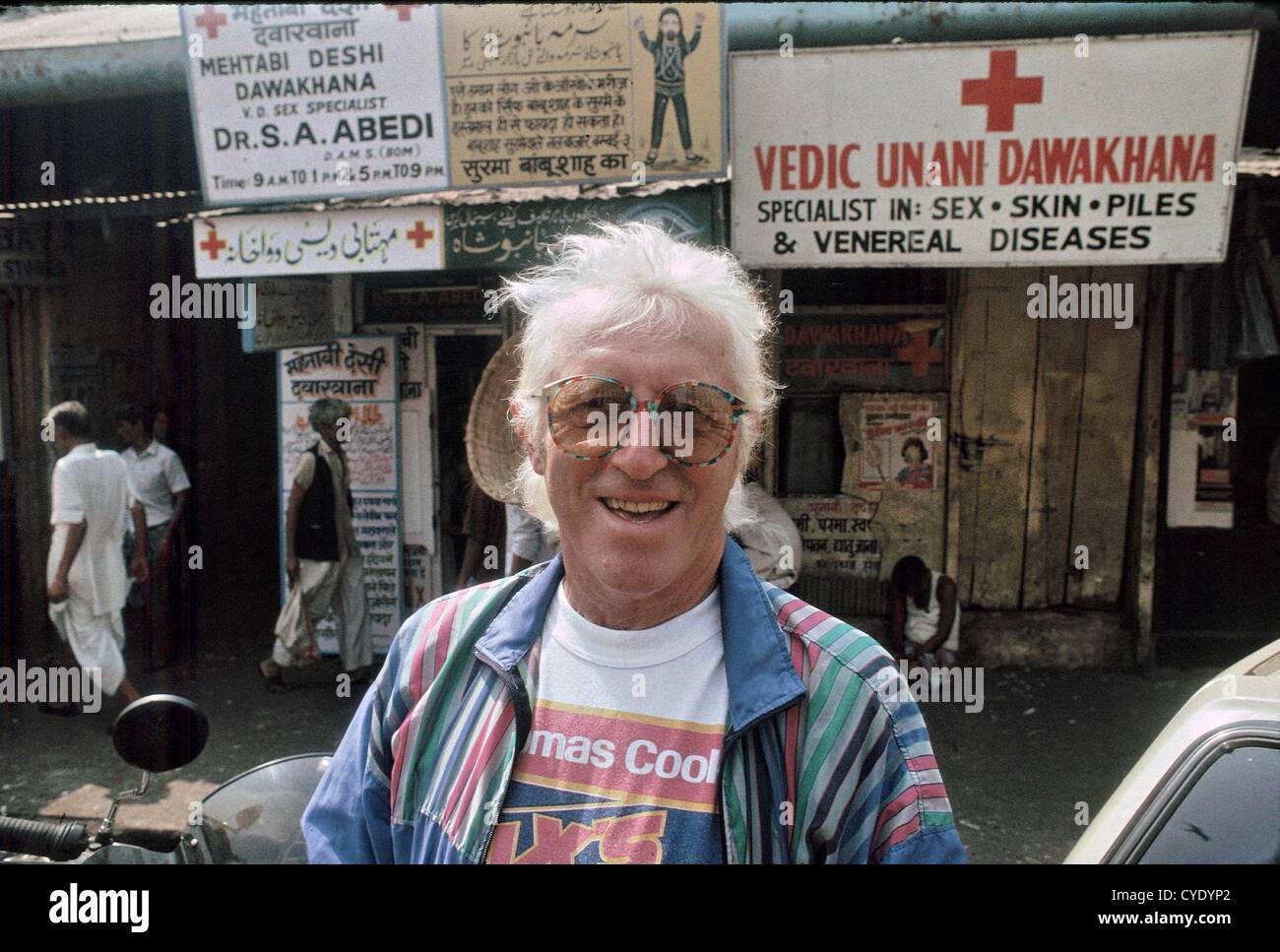 Scandale d'abus sexuel Sir Jimmy Savile, OBE illustré à l'extérieur d'un sexe clinique à Mumbai, en Inde, en 1992. Pendant que les autres passagers ont visité les sites touristiques, Savile a fait une excursion à un macabre crématorium hindou et les tours du silence, où les membres de la secte des Zoroastriens laisser leurs morts dans l'Open d'être dévoré par les vautours et autres oiseaux de proie. Le disc-jockey et personnalité de la radio et de la télévision a été "tournant autour du monde", la collecte de fonds pour les organismes de bienfaisance et d'autres de Stoke Mandeville.Savile, est au centre de nombreuses allégations de violence envers les enfants. Il est mort à l'âge de 84 ans le 29 octobre . Banque D'Images