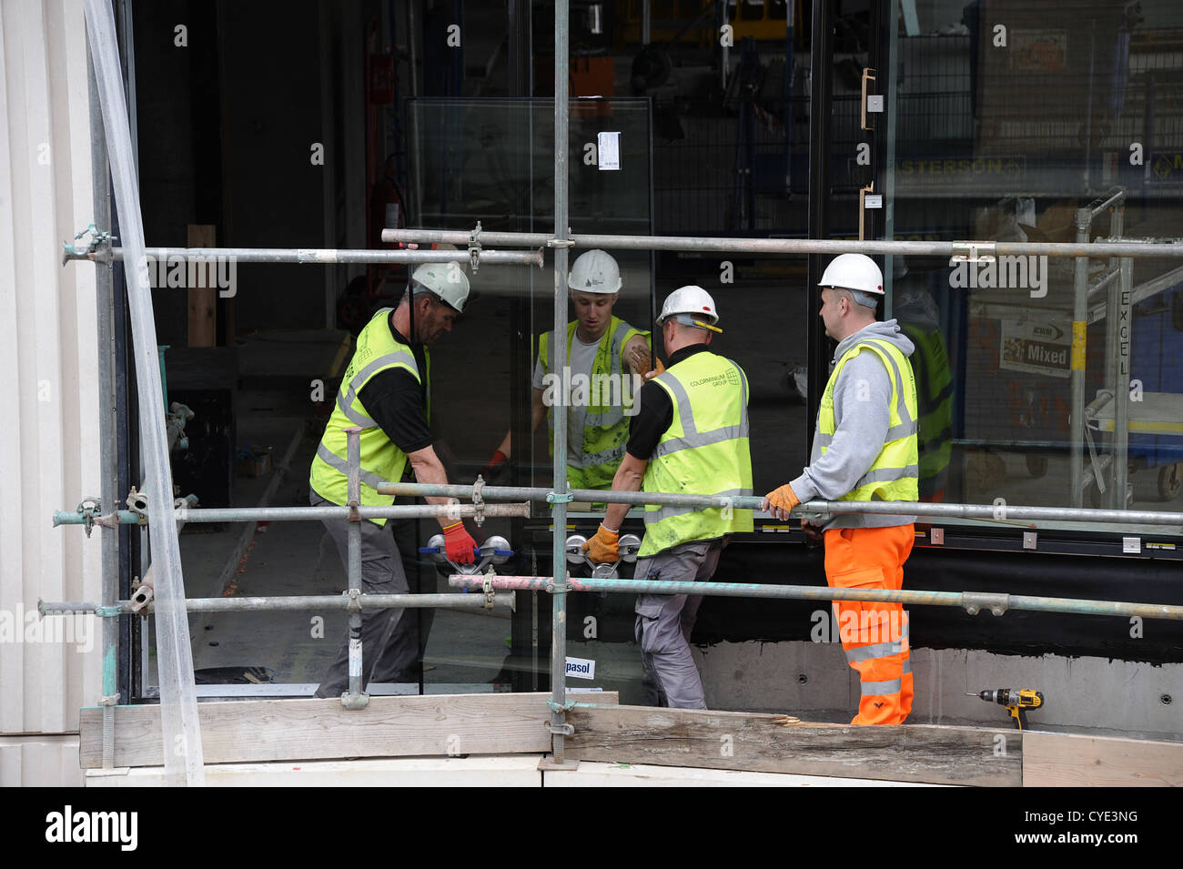 Installer les panneaux de verre lourds constructeurs dans le nouveau bâtiment à Londres. Banque D'Images