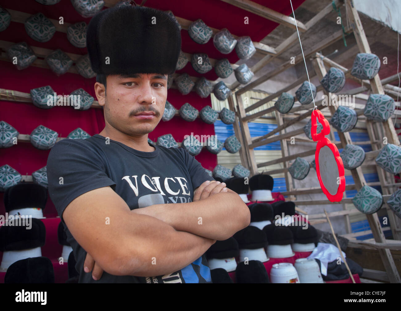 Jeune homme musulman Doppi vente Chapeaux, Marché du Village d'Opale, la région autonome ouïghoure du Xinjiang, Chine Banque D'Images