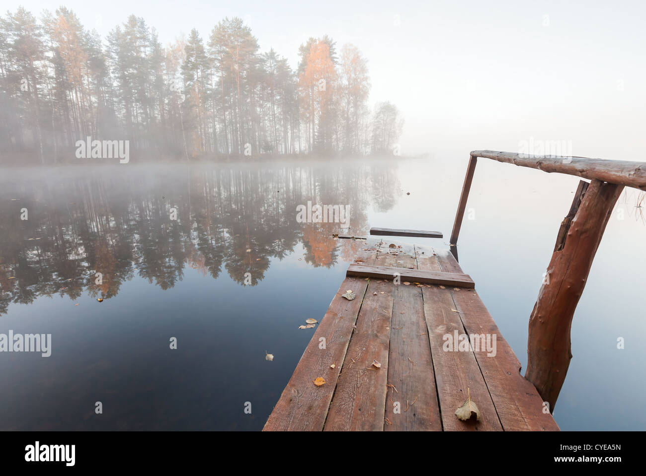 Petite jetée en bois sur le lac encore dans le froid matin brumeux Banque D'Images