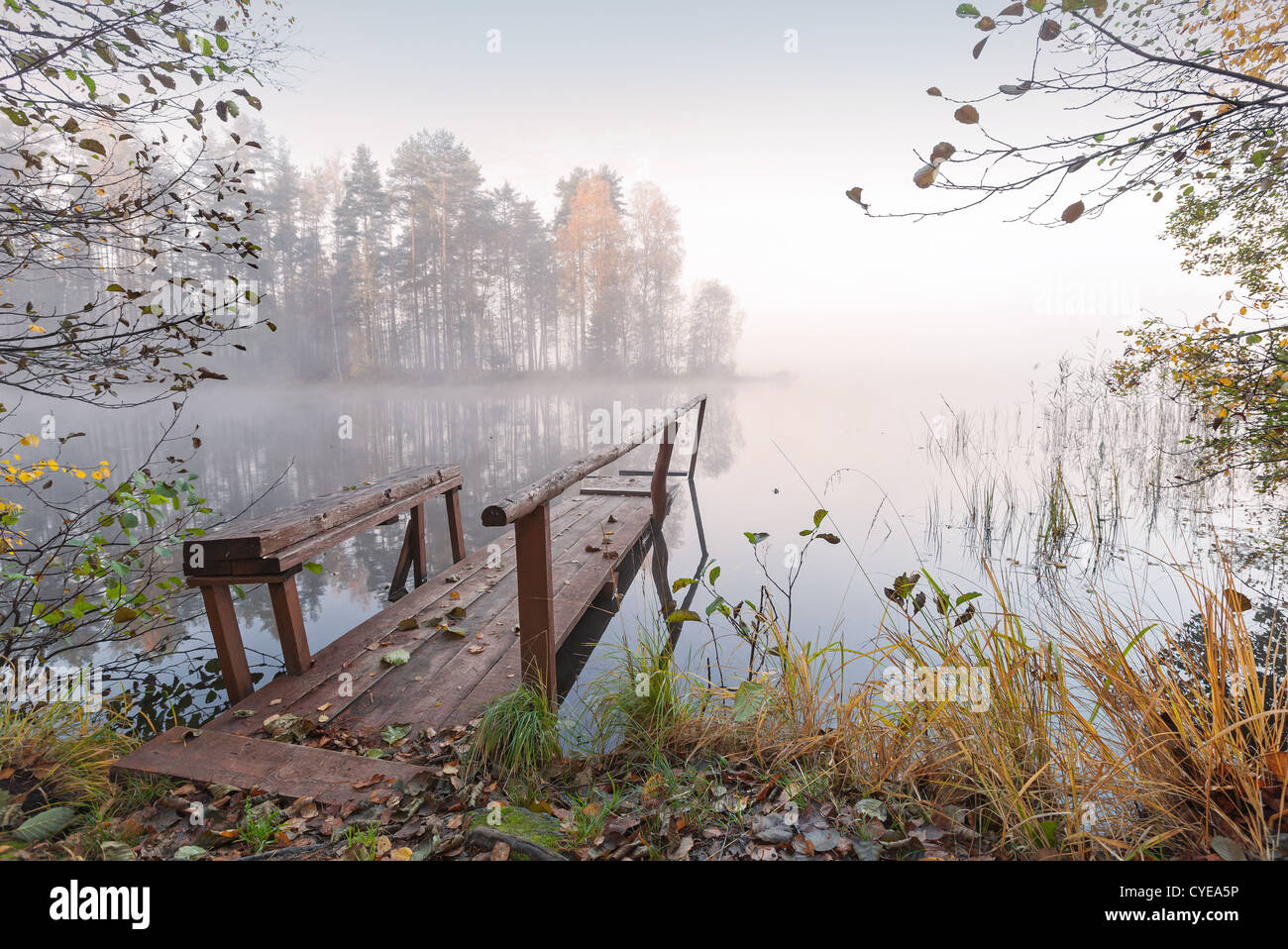 Petite jetée en bois sur le lac toujours en automne Matin brumeux Banque D'Images