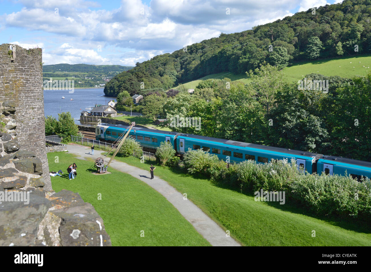 Holyhead à la ligne à côté de murs du château avec le train arriva à propos de traverser Stephenson a pont sur la rivière Conwy Banque D'Images