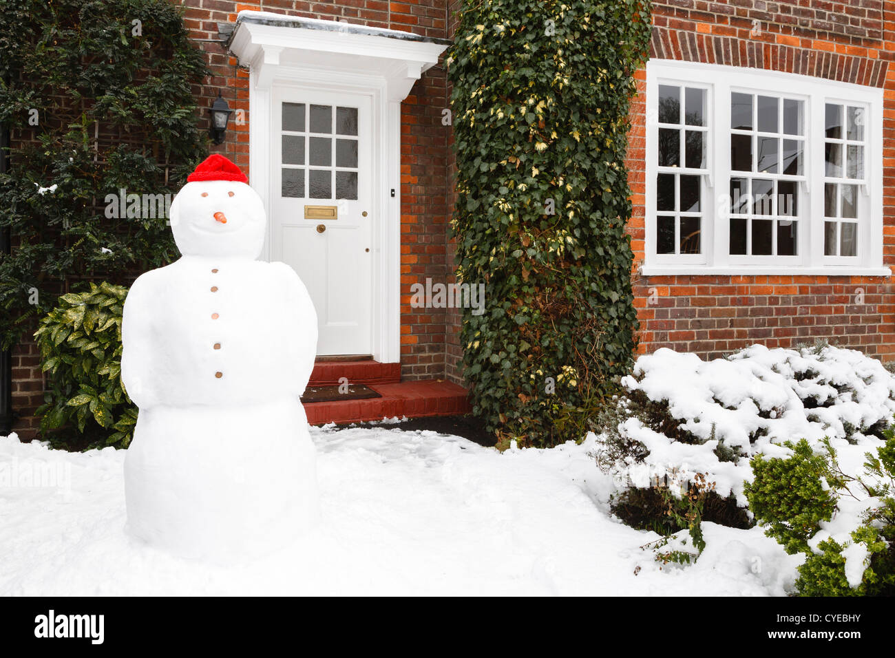 Bonhomme de neige dans le jardin avant de l'accueil en hiver Banque D'Images
