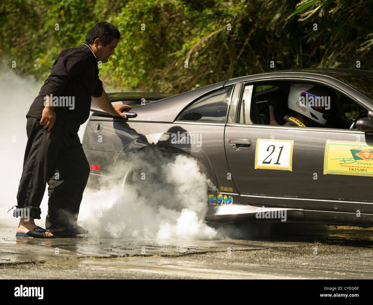Faites glisser Okinawan Racers effectuer un burnout pour chauffer les pneus avant la course Banque D'Images