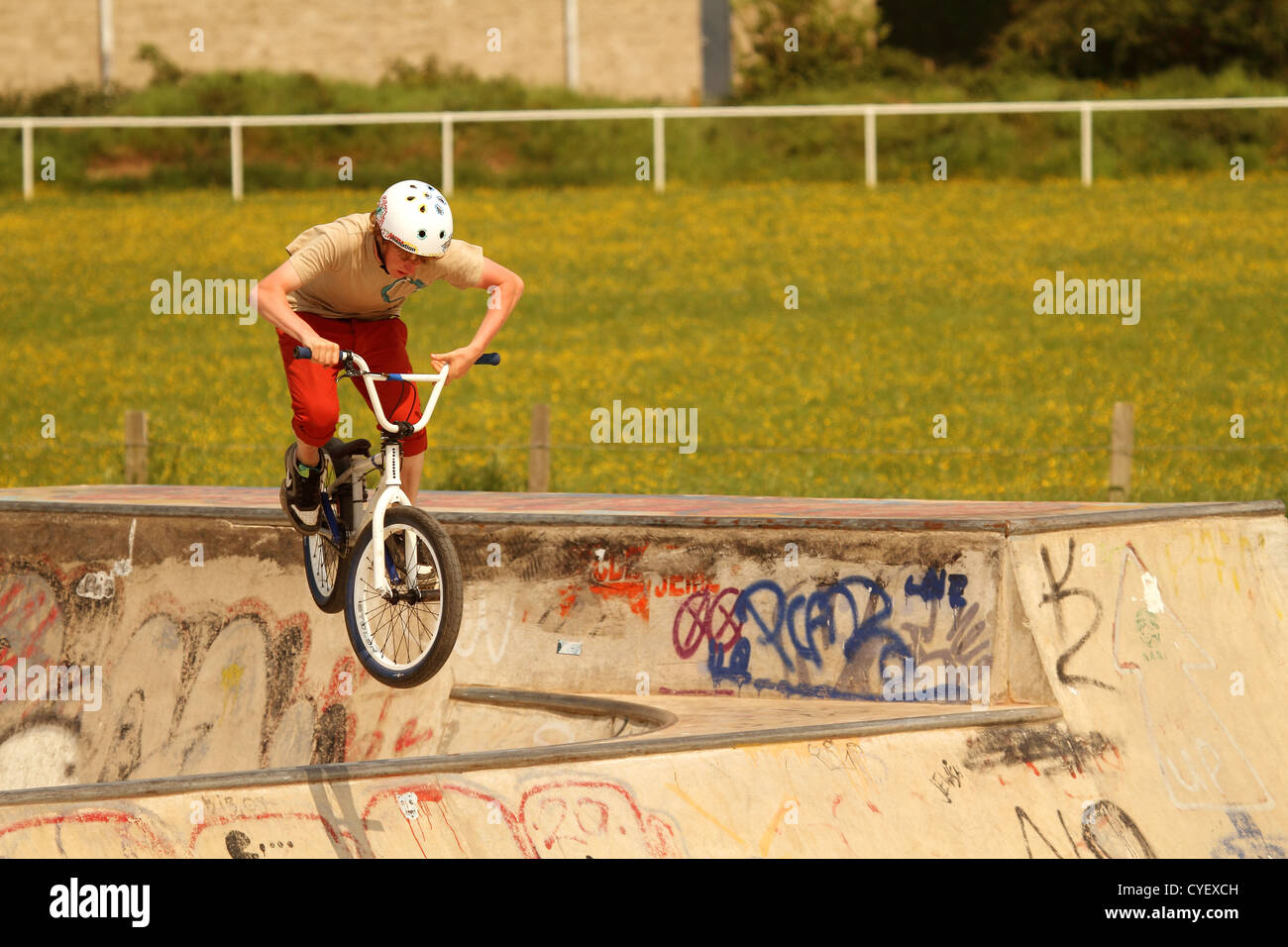 Jeune homme jouant sur son vélo BMX sur le skate park de Cheddar Banque D'Images