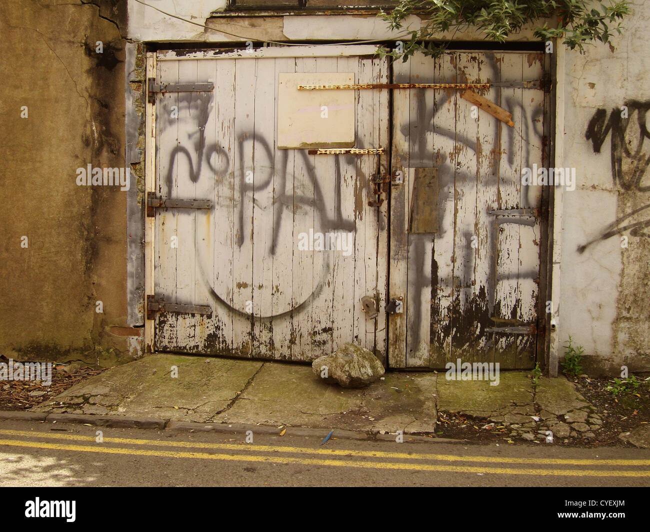 Ancien garage avec porte de graffitis dans une course vers le bas de la ville Banque D'Images